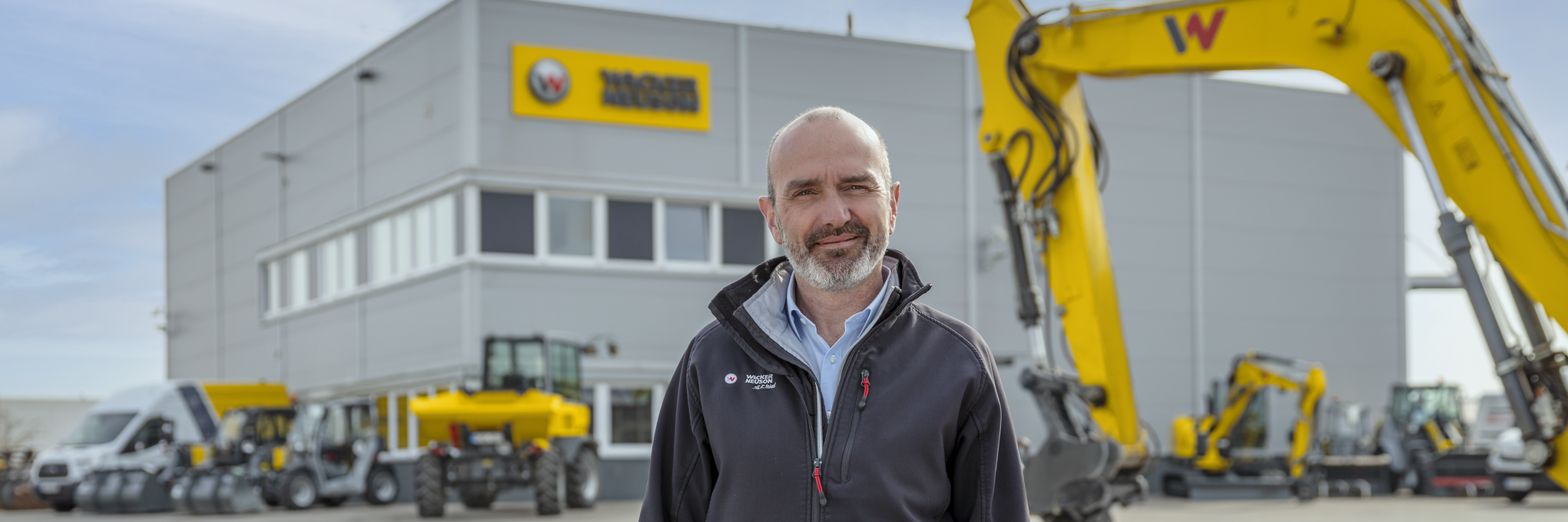 Wacker Neuson Mitarbeiter steht vor Wacker Neuson Mietstation.