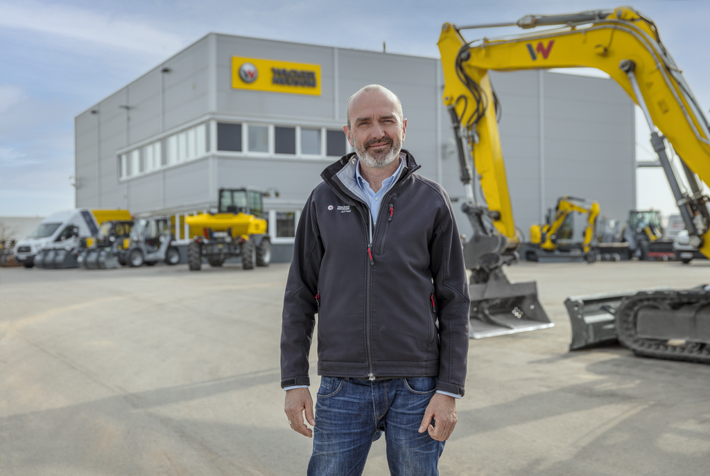 Wacker Neuson Mitarbeiter steht vor Wacker Neuson Mietstation.