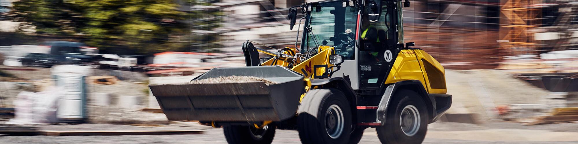 Der Performance-Radlader WL950p von Wacker Neuson fährt mit hoher Geschwindigkeit auf einer Baustelle.