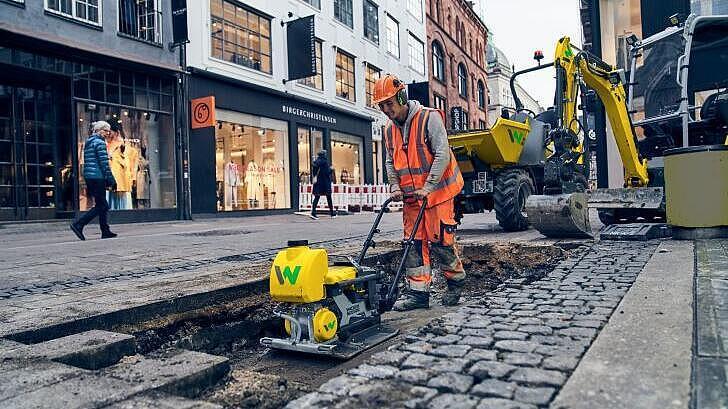 Piastre vibranti monodirezionali della serie a zero emission di Wacker Neuson in uso su un cantiere in città.