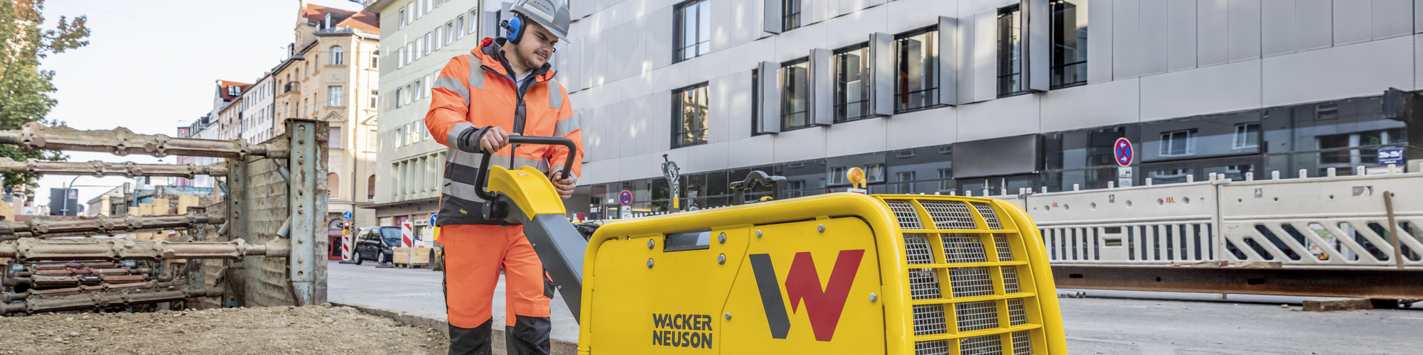 Eine Wacker Neuson Vibrationsplatte in Aktion auf einer Baustelle in der Stadt.