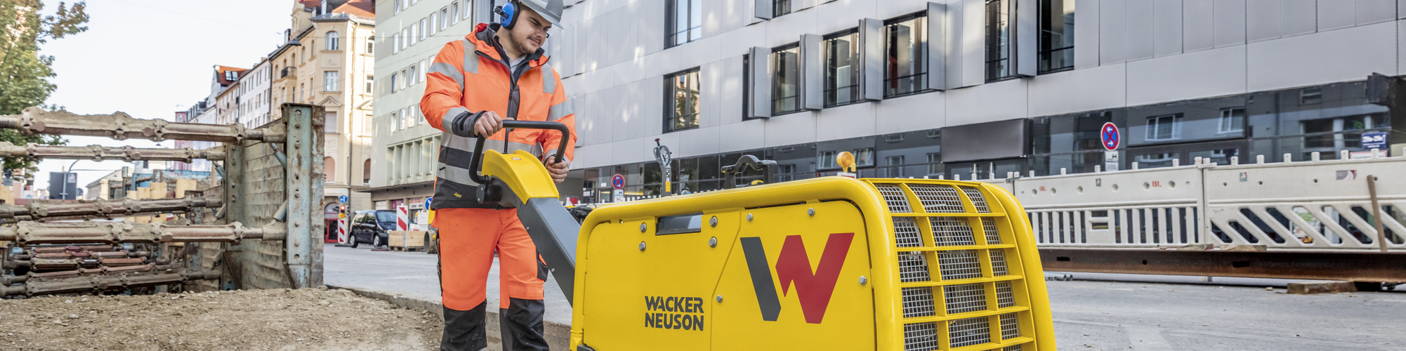 Une plaque vibrante Wacker Neuson en action sur un chantier en ville.